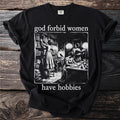 Black t-shirt with text "god forbid women have hobbies" and vintage illustration of women reading and writing.