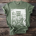 Green t-shirt with graphic of a raccoon holding food in a refrigerator.