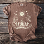 Brown t-shirt with a sun, campfire, and figures surrounding the fire.