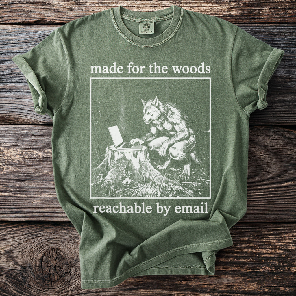 Green t-shirt with graphic of werewolf on laptop and text "made for the woods reachable by email."