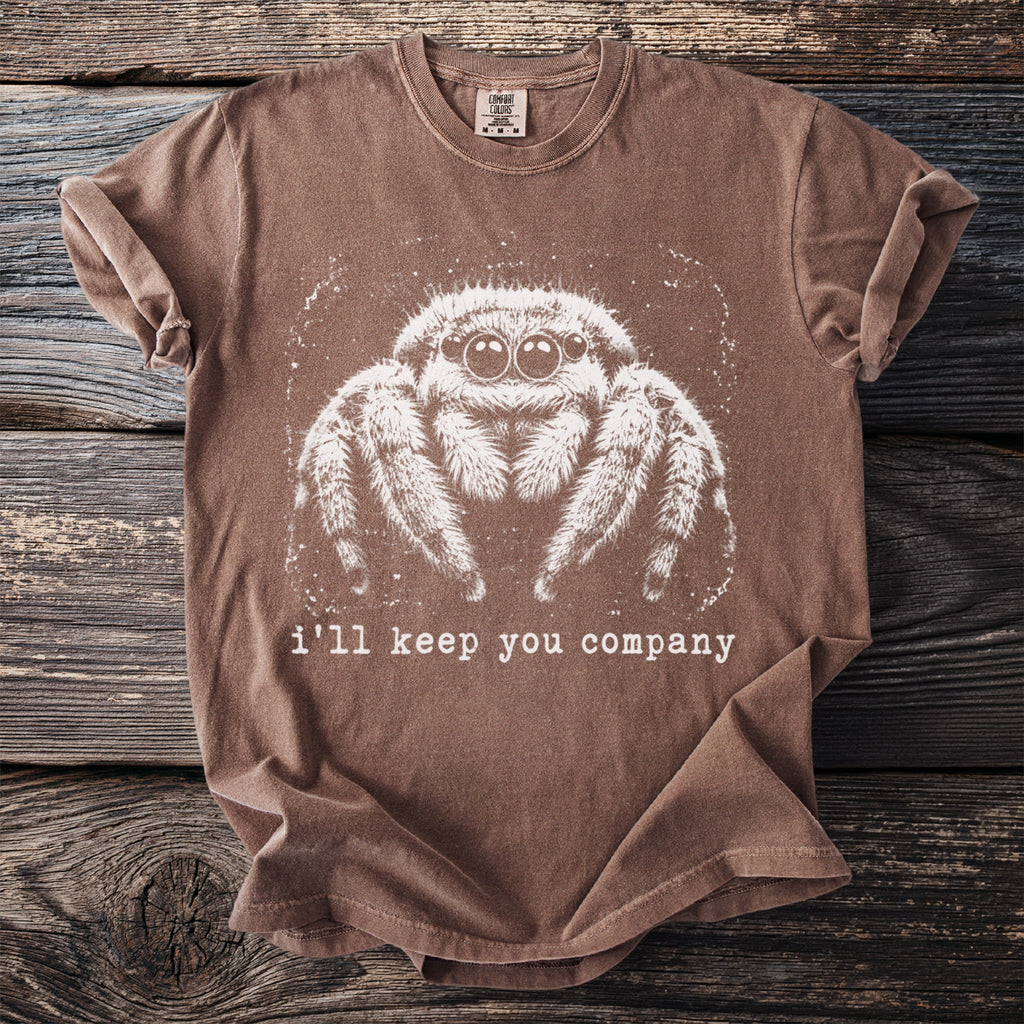 Brown t-shirt featuring a white graphic of a fuzzy spider and text "i'll keep you company".