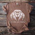 Brown t-shirt featuring a white graphic of a fuzzy spider and text "i'll keep you company".
