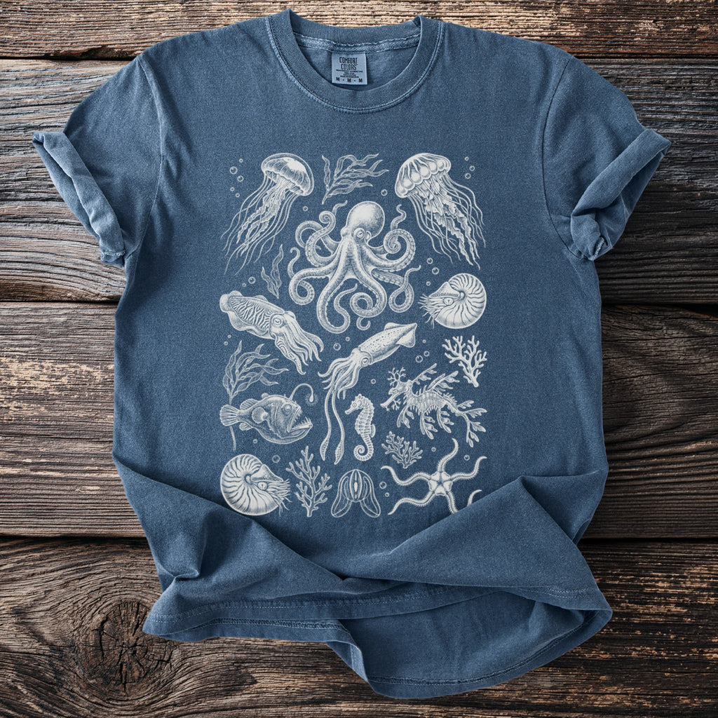 Blue t-shirt featuring a detailed white line drawing of various sea creatures and plants.