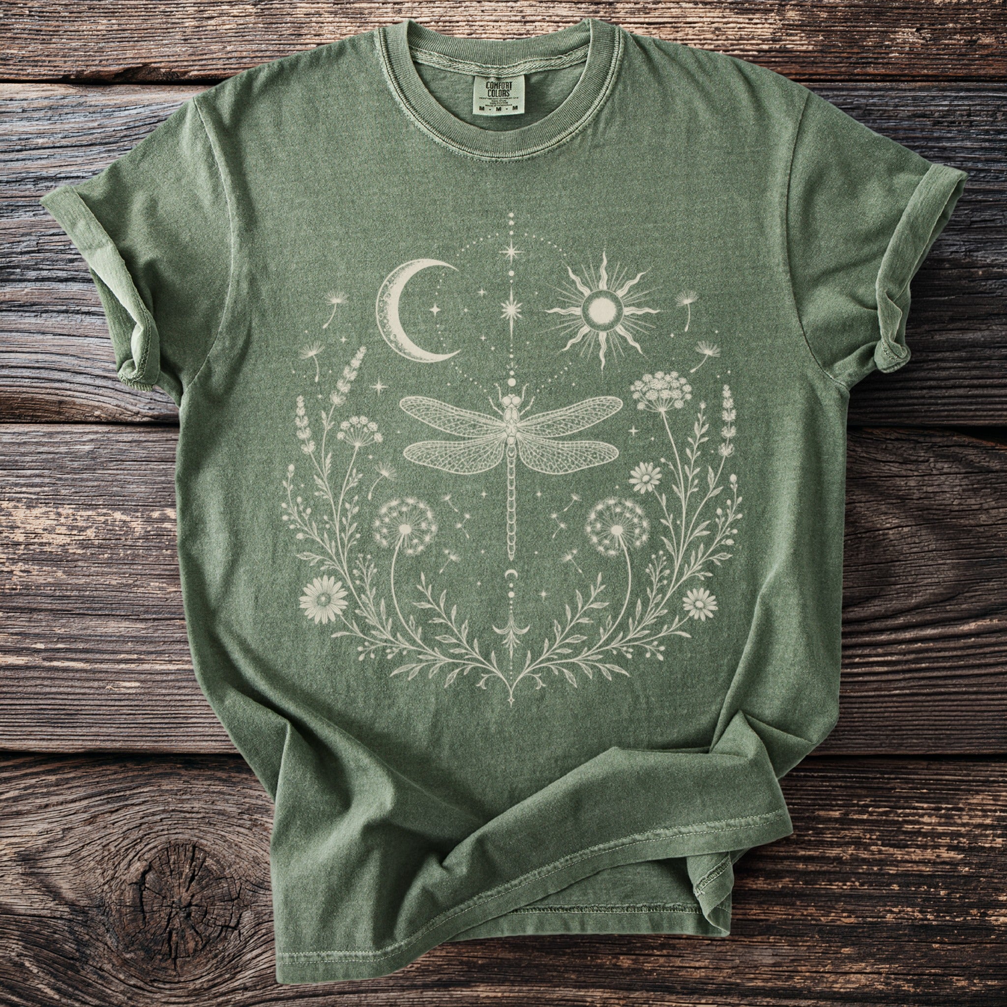 Green t-shirt with white dragonfly, sun, moon, and floral design.