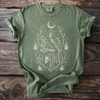 Green t-shirt with a mystical graphic of a person, snake, wolf, and flames.