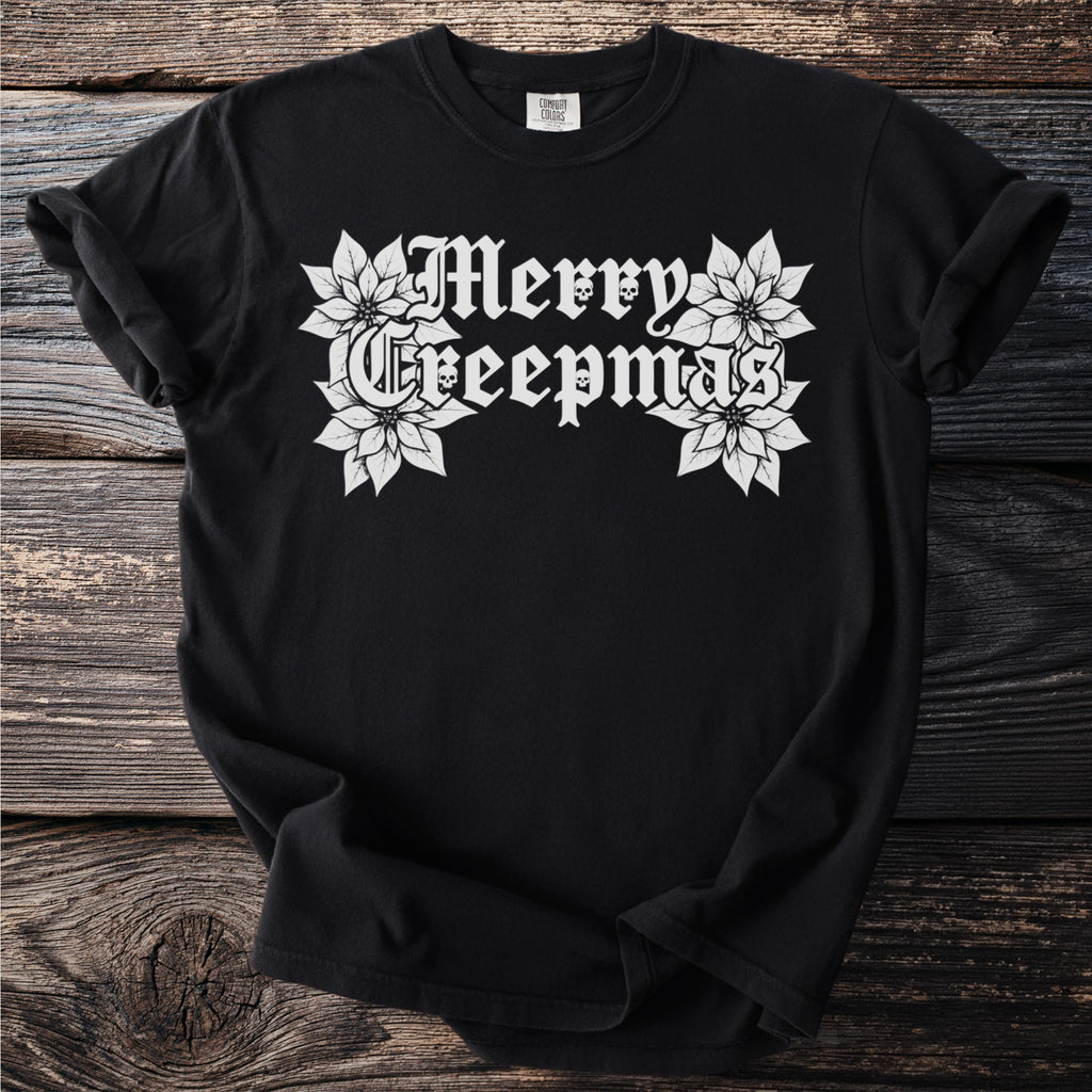 Black t-shirt with white "Merry Creepmas" text, skulls, and poinsettias.