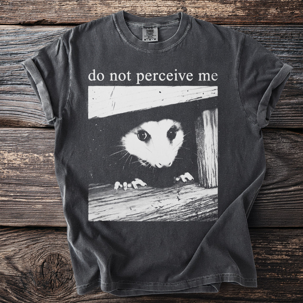 T-shirt with opossum peering from a dark opening and text "do not perceive me".