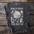 Dark grey t-shirt with a sketch of a hut on chicken legs and the text "HOME IS WHERE THE HUT IS".