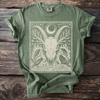 Green t-shirt with a detailed graphic of a goat skull, moon, crows, and runes.