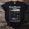 Black t-shirt with "Brown Mountain Lights" design featuring a silhouetted figure and glowing lights.