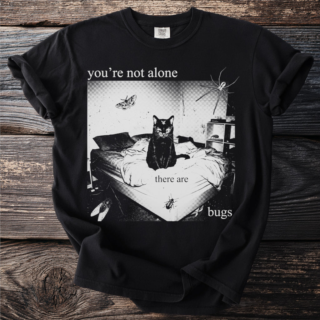 Black t-shirt with a bed, black cat, spider, moth, and beetle graphic with text.