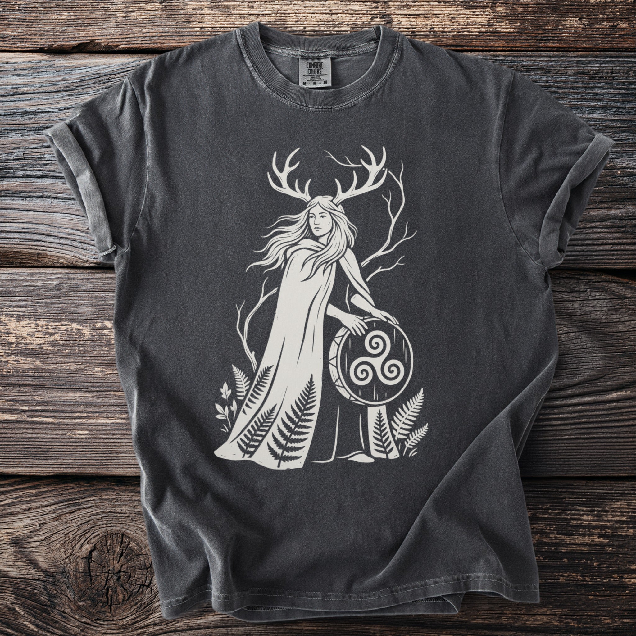 Dark grey t-shirt with white print of a woman with antlers holding a triskelion shield.