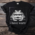 Black t-shirt with a close-up vintage-style graphic of a toad and text "i have warts."