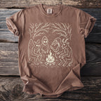 Brown t-shirt with a white graphic of cryptids around a campfire.