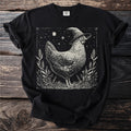 Black t-shirt with a stylized chicken wearing a witch hat and surrounded by stars.