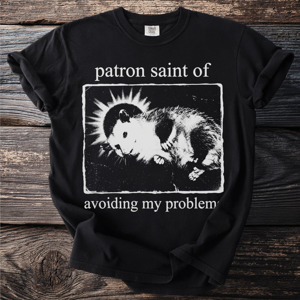 Black t-shirt with "patron saint of avoiding my problem" and a hamster graphic.