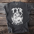 Dark t-shirt with white graphic of Tyr and Fenrir wolf bound by chains.