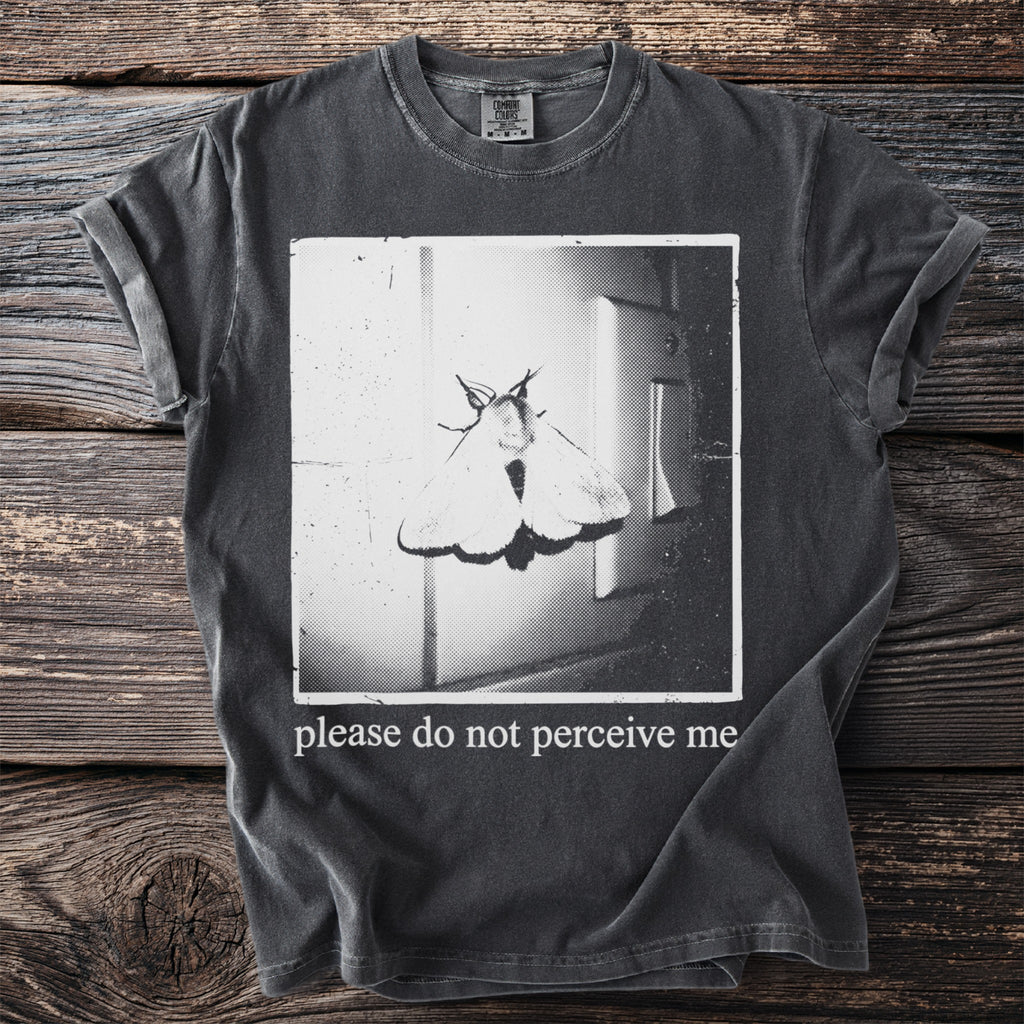 Dark t-shirt with a moth graphic and "please do not perceive me" text.