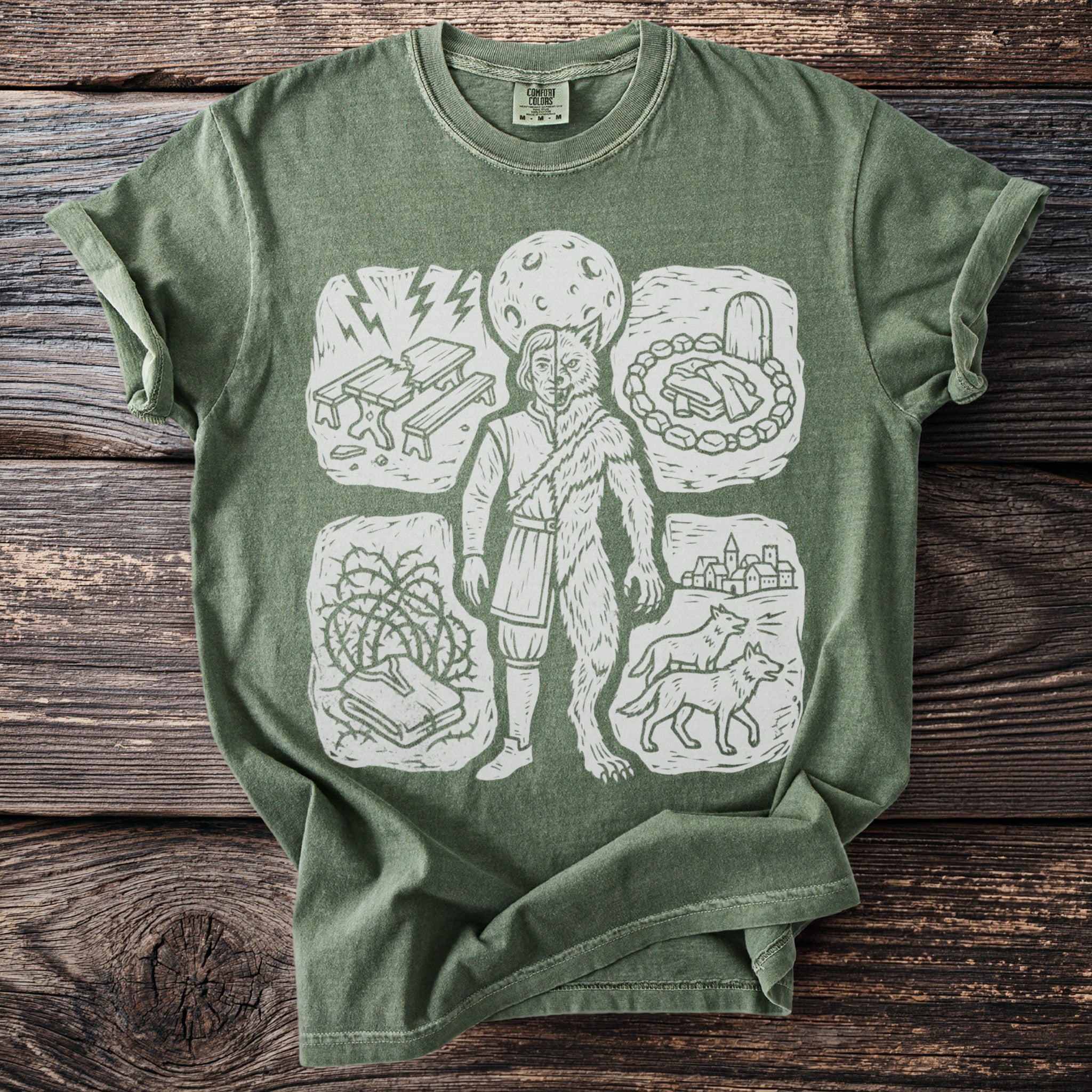 Green t-shirt with a linocut print of a werewolf and surrounding vignettes.