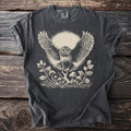 Dark grey t-shirt with a cream linocut design of an owl in flight over mushrooms.