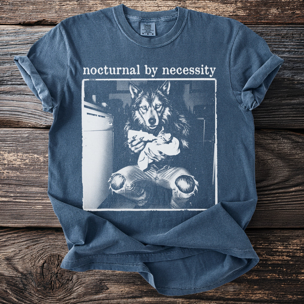 Blue t-shirt with "nocturnal by necessity" and graphic of wolf feeding a kitten.
