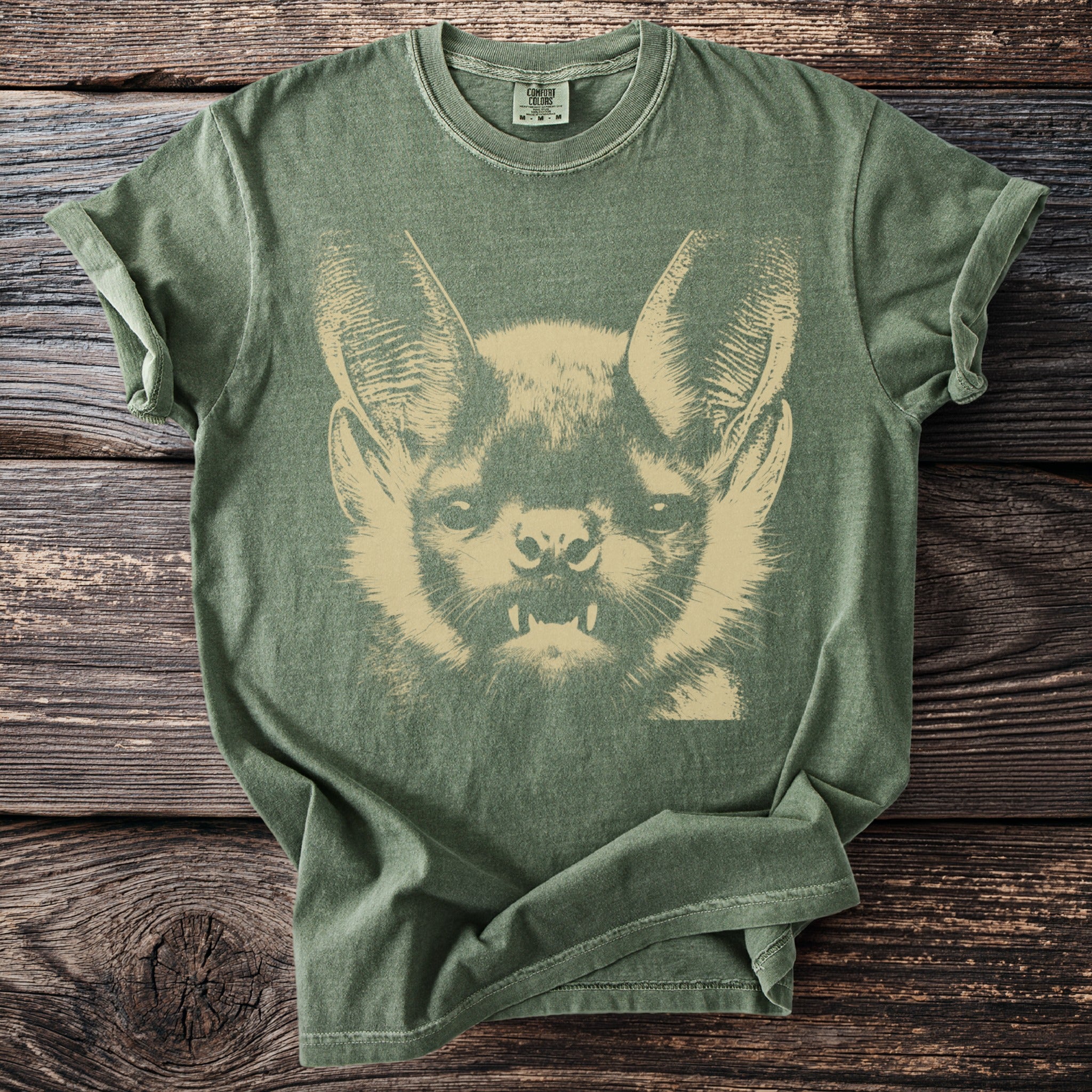 Green t-shirt with a stencil-style print of a bat's face.