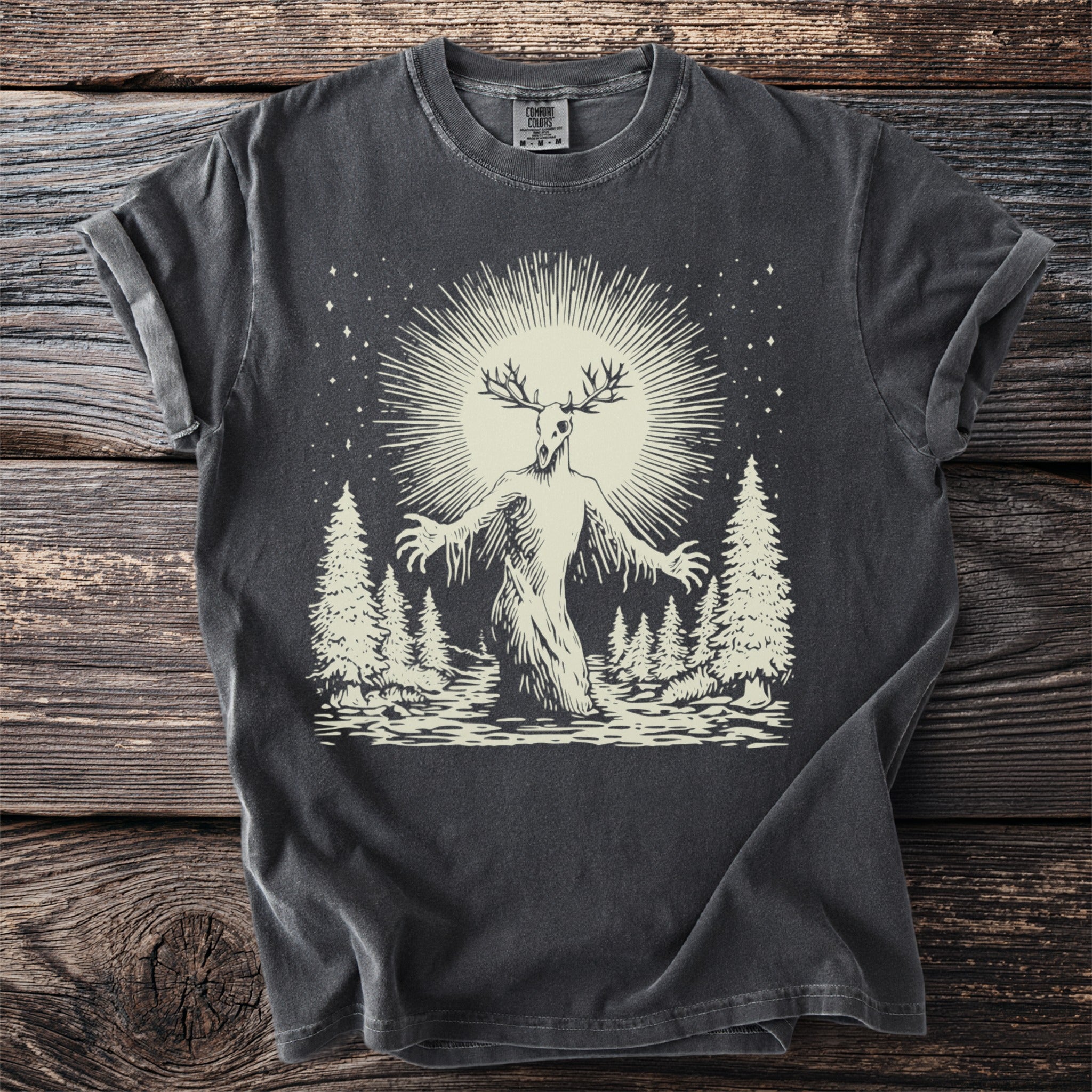 Dark t-shirt with a cream linocut style graphic of a deer-headed creature.