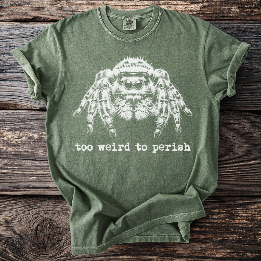 Green t-shirt with white graphic of a jumping spider and text "too weird to perish".