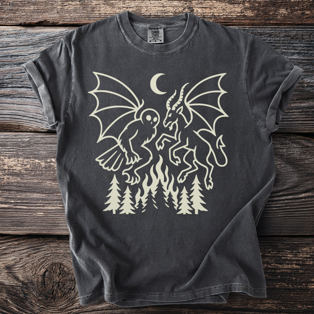 Dark gray t-shirt with cream graphic of mythical creatures, moon, fire, and trees.