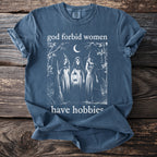 Dark blue t-shirt with "god forbid women have hobbies" and witch graphic.