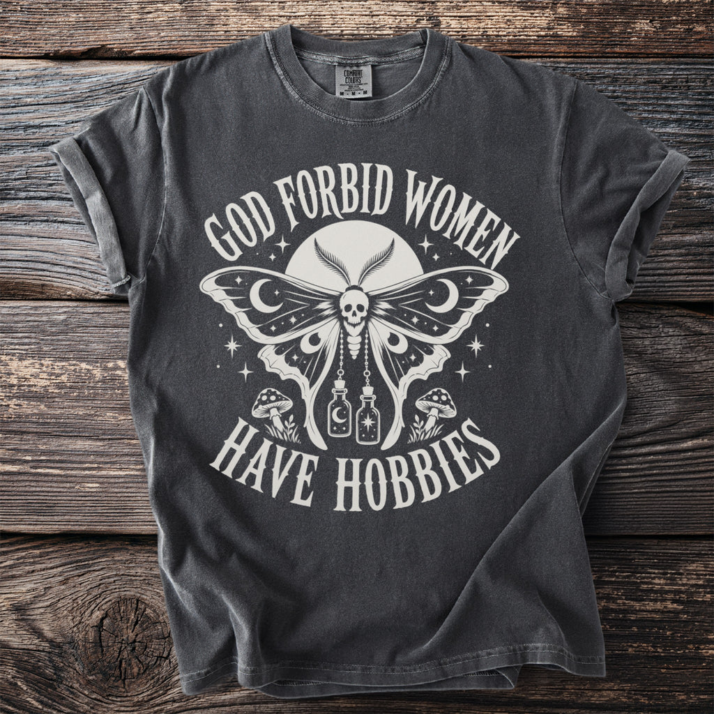 Dark grey t-shirt with moth graphic and text "GOD FORBID WOMEN HAVE HOBBIES".