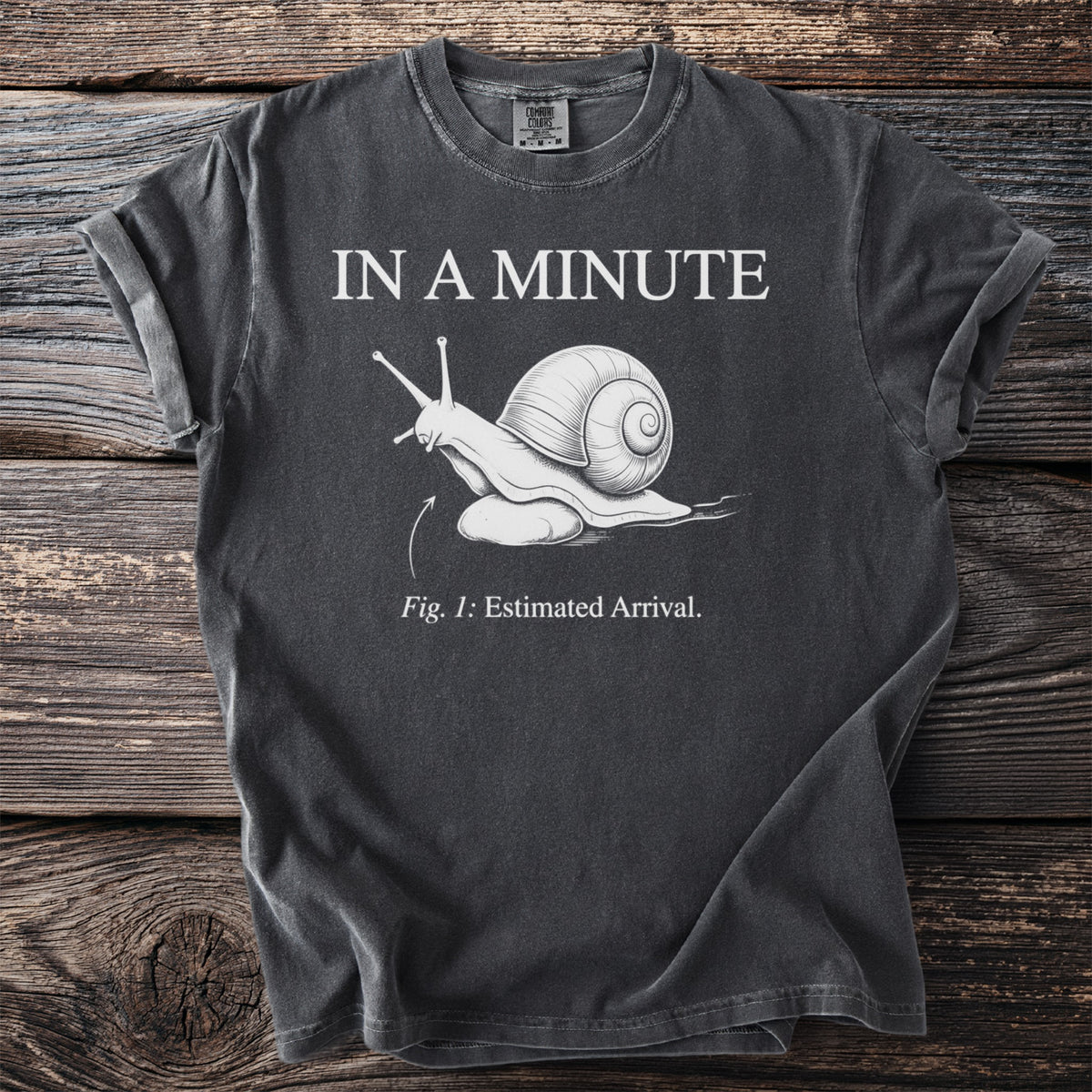Dark gray t-shirt with white text "IN A MINUTE" and a drawing of a snail.