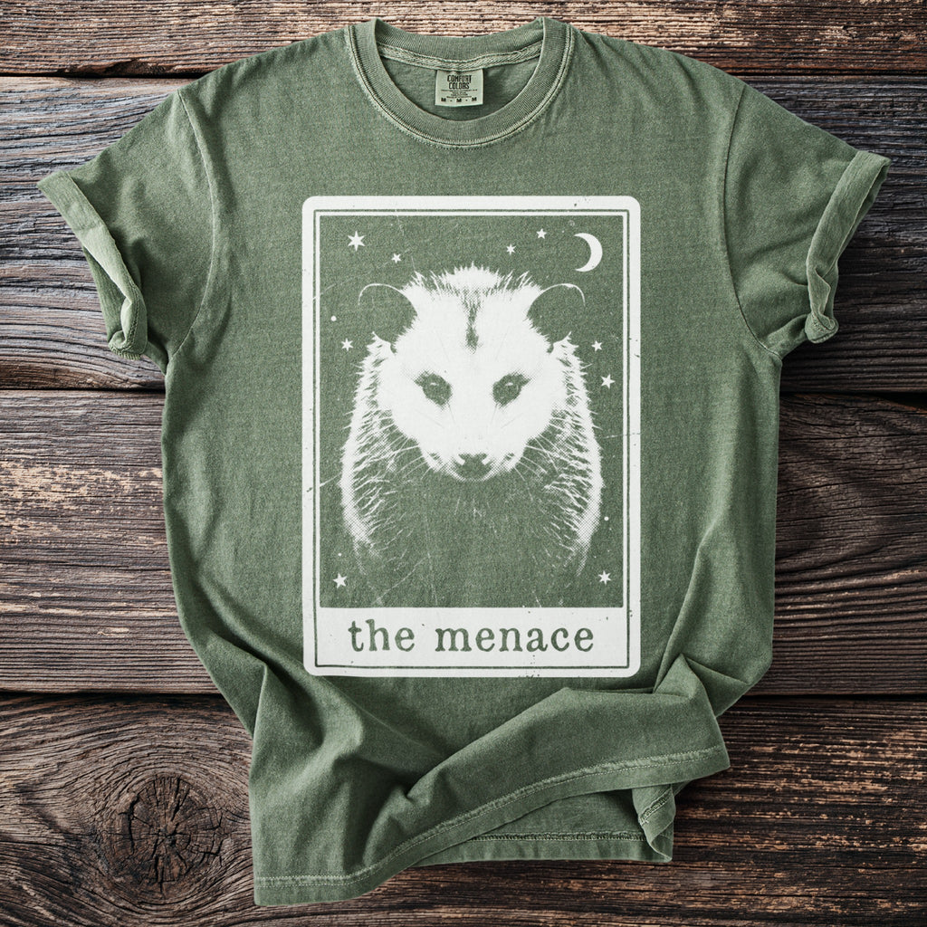 Opossum graphic on a green t-shirt with "the menace" text.