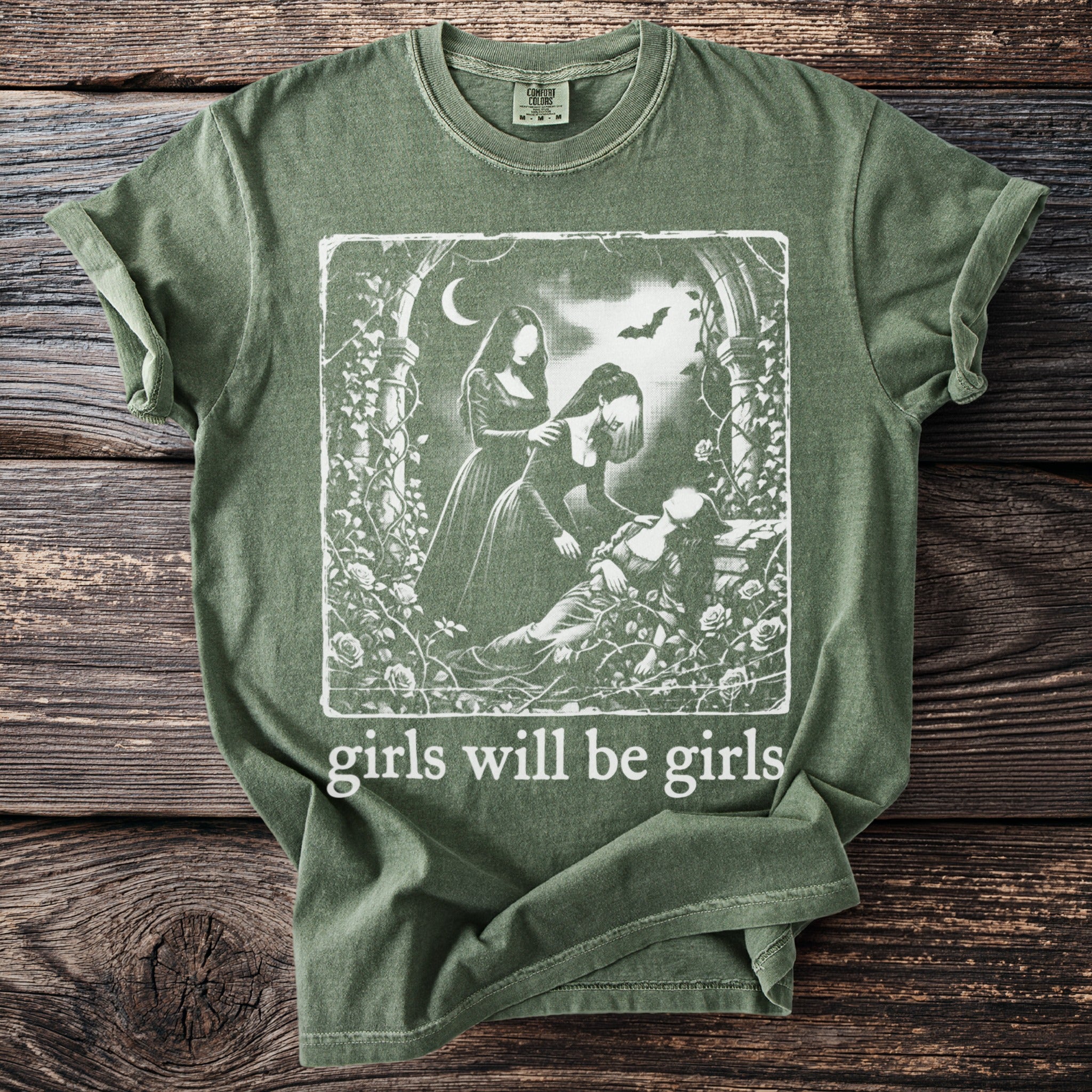 Green t-shirt with a gothic illustration and text "girls will be girls"