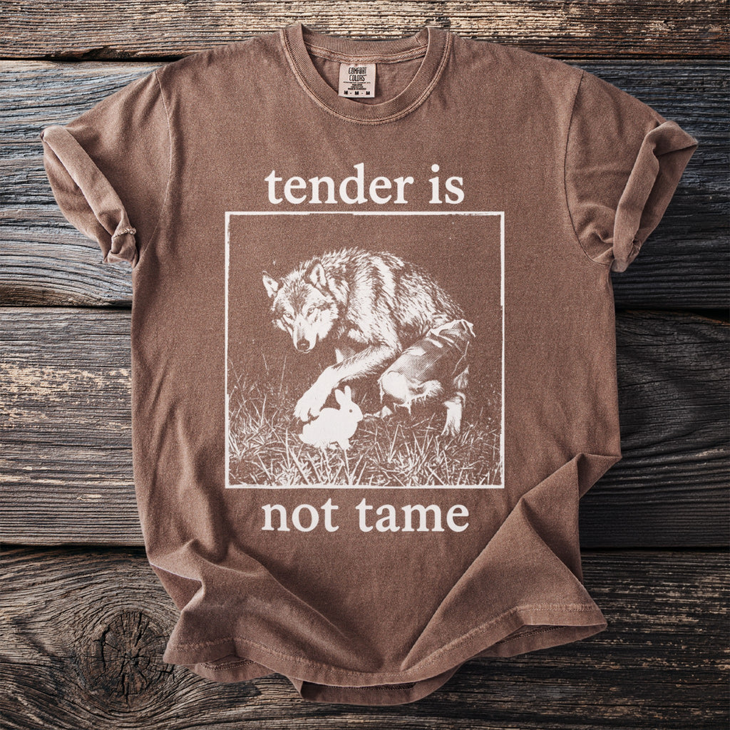 Brown t-shirt with "tender is not tame" and a wolf with a rabbit graphic.
