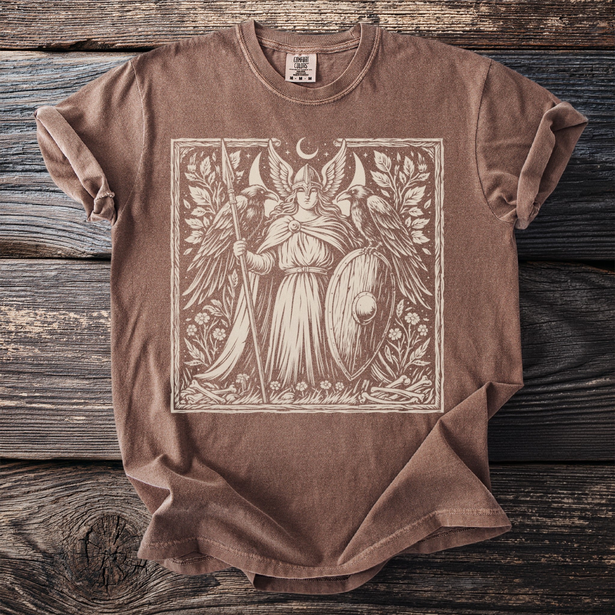 Brown t-shirt with a cream linocut style print of a winged warrior with a spear and shield.