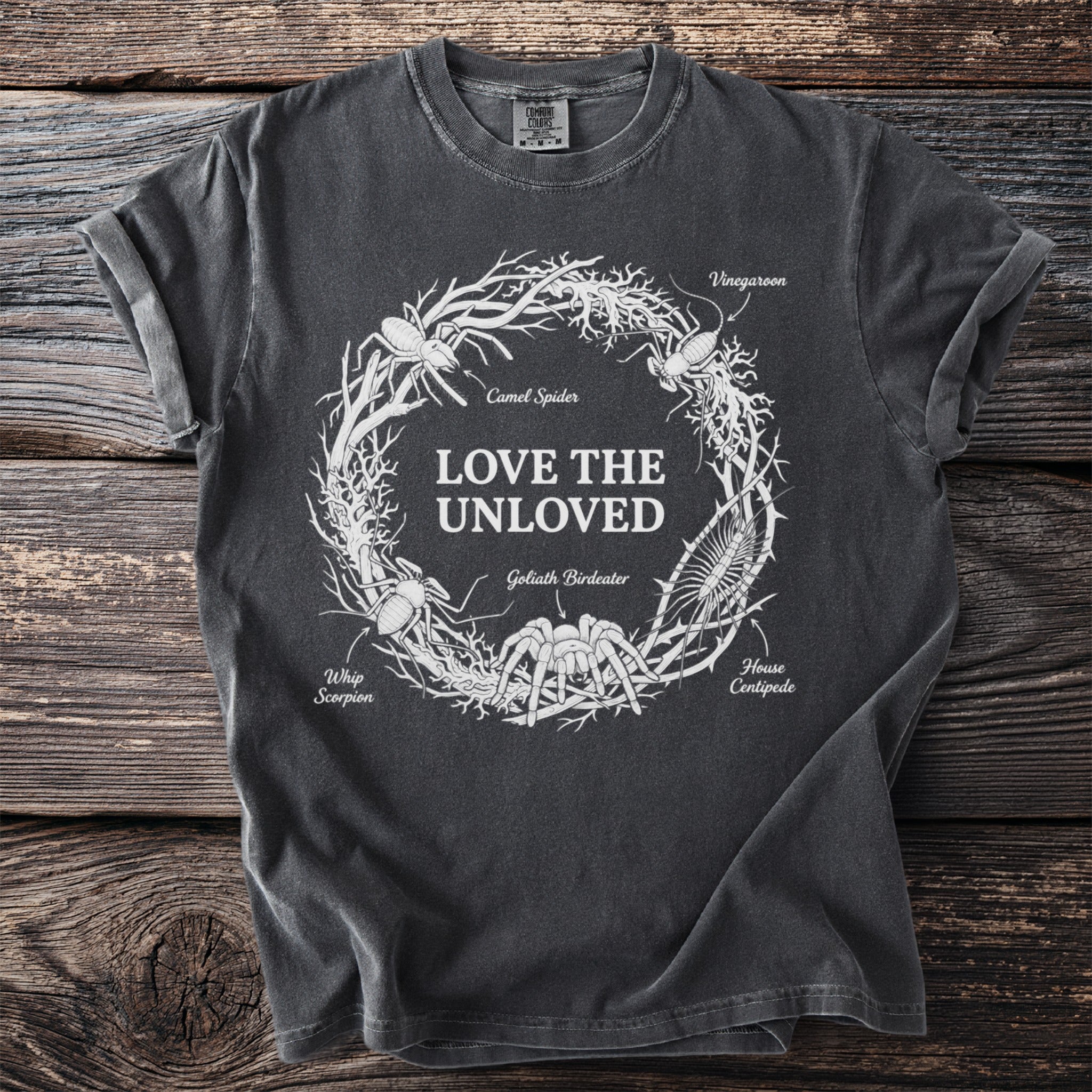 Dark t-shirt with "LOVE THE UNLOVED" and illustrated insects in a wreath.