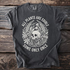 Dark grey t-shirt with a circular graphic of a skull, plants, mushrooms, and the text "ALL PLANTS ARE EDIBLE SOME ONLY ONCE."
