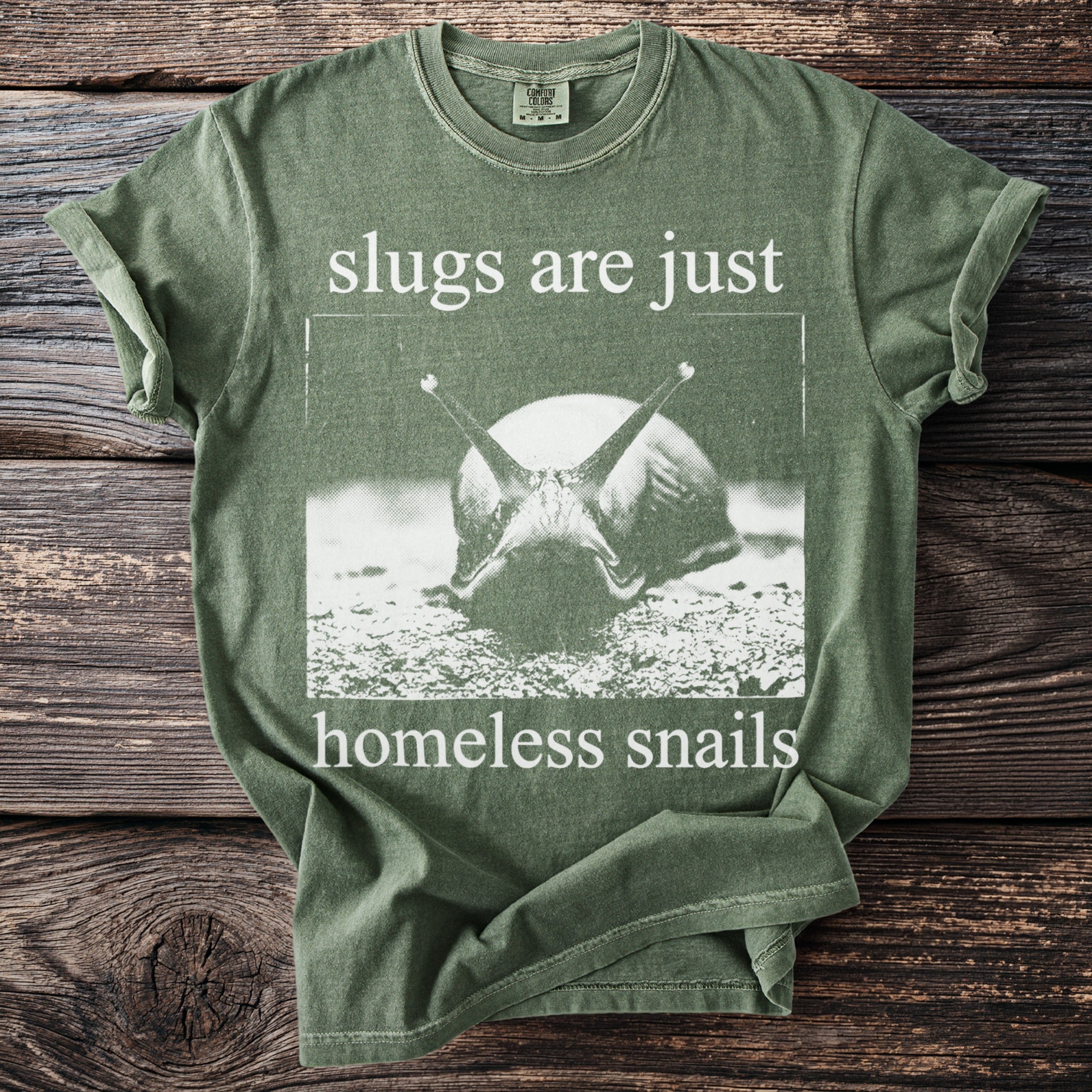 Green t-shirt with graphic of a snail and text: "slugs are just homeless snails".