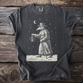 Pepper gray t-shirt with a cream folk-cut print: a plague doctor in beaked mask, hat and long coat walks through falling snow with a lantern.