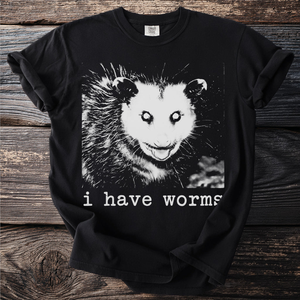 Black t-shirt with a graphic of an opossum and text "i have worms".