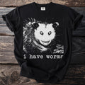 Black t-shirt with a graphic of an opossum and text "i have worms".