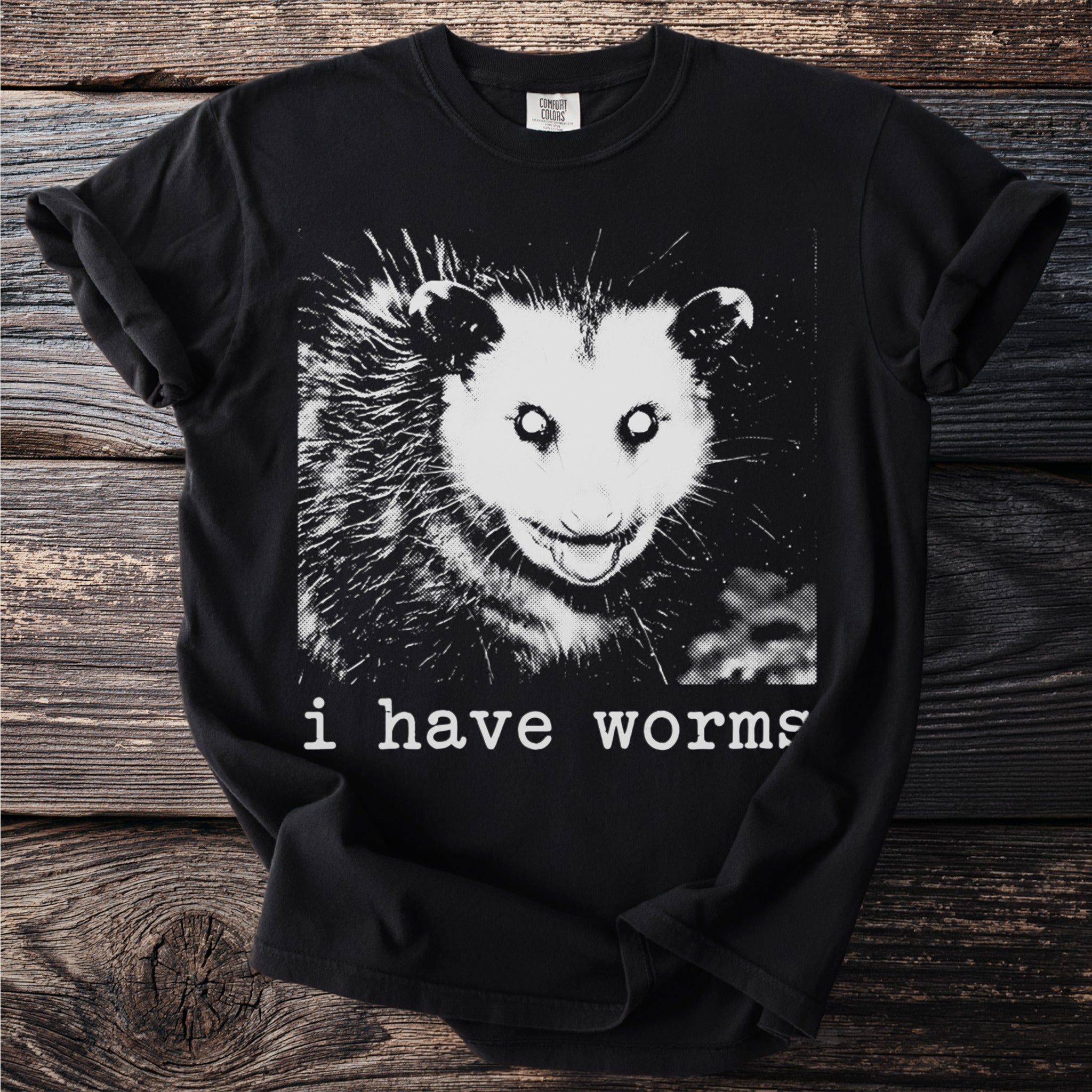 Black t-shirt with a graphic of an opossum and text "i have worms".
