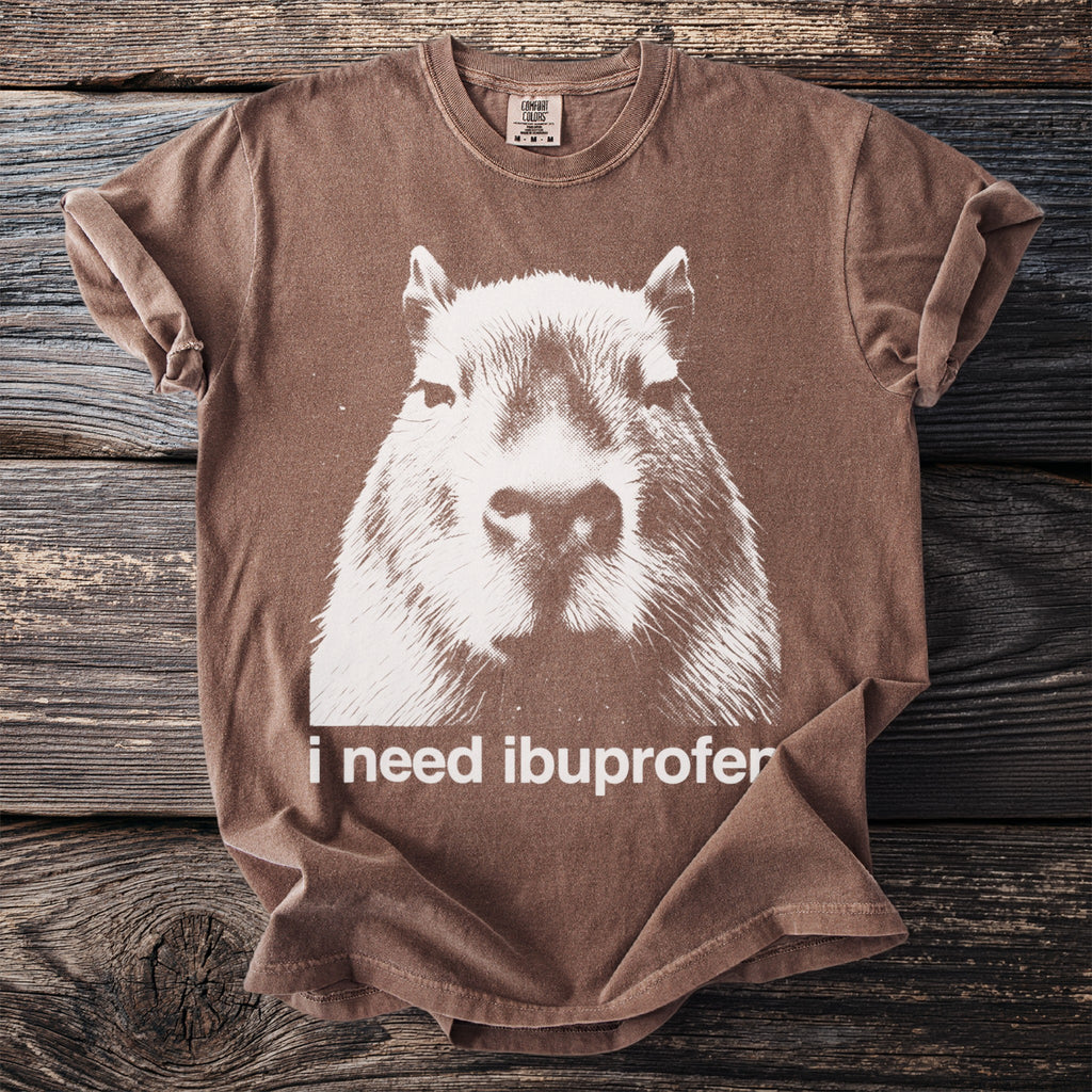 Brown t-shirt with white capybara graphic and text "i need ibuprofen".