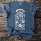 Blue t-shirt with a white gothic window design featuring a skull, plants, poison bottle, and text.