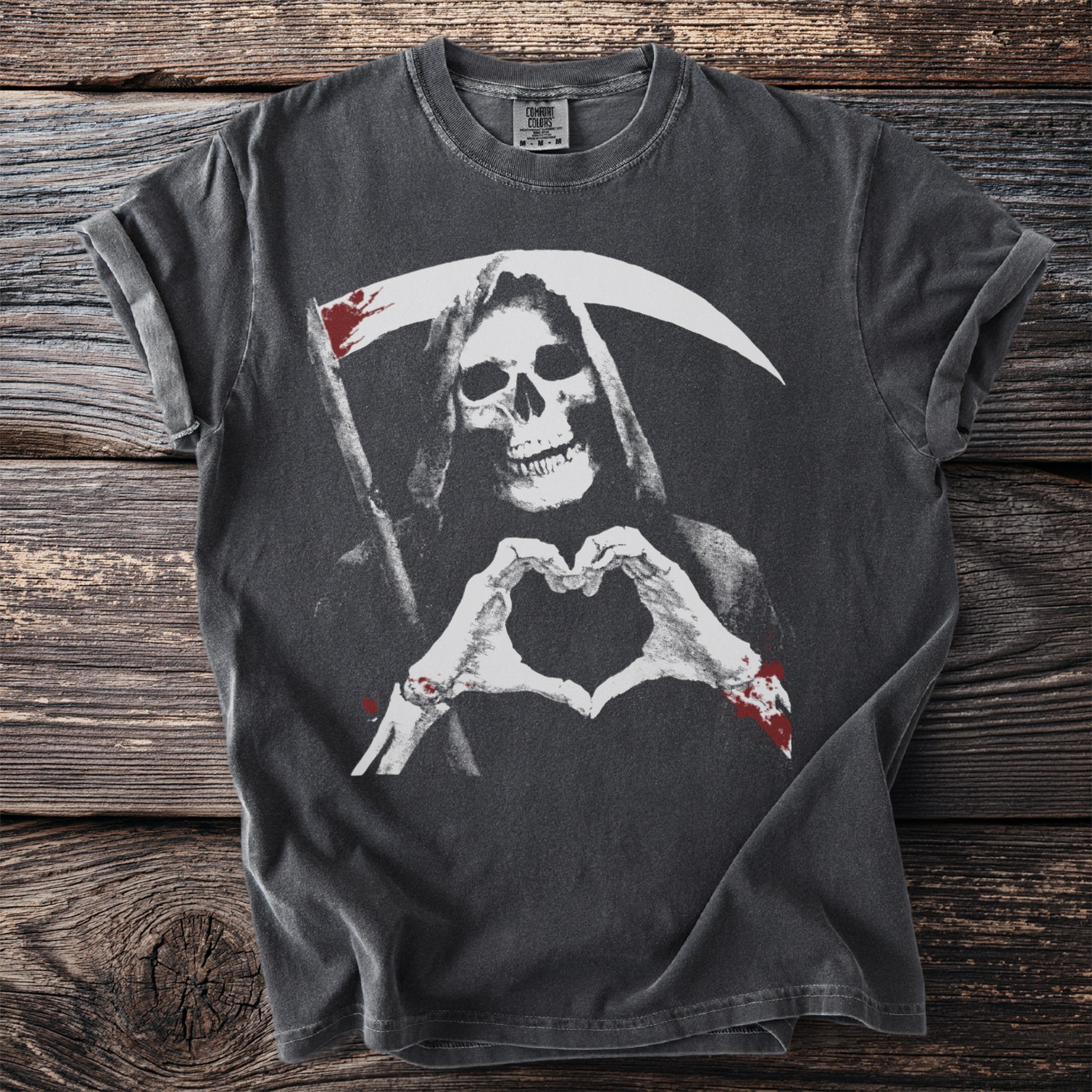 Grim reaper making a heart shape with skeleton hands on a charcoal t-shirt.