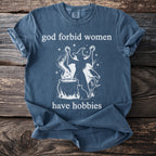 Blue t-shirt with "god forbid women have hobbies" text and witch graphic.