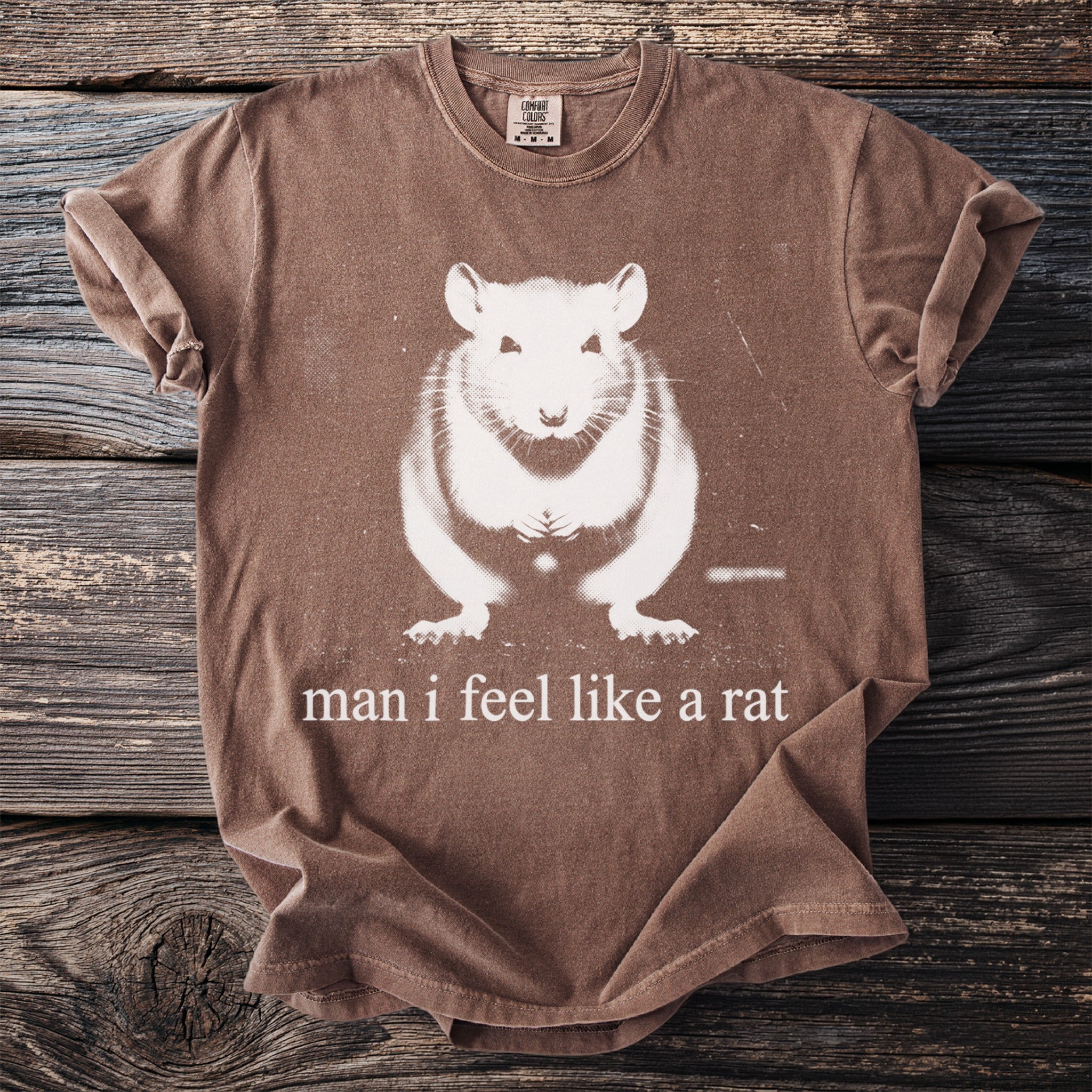 Brown t-shirt with a white graphic of a rat and the text "man i feel like a rat".