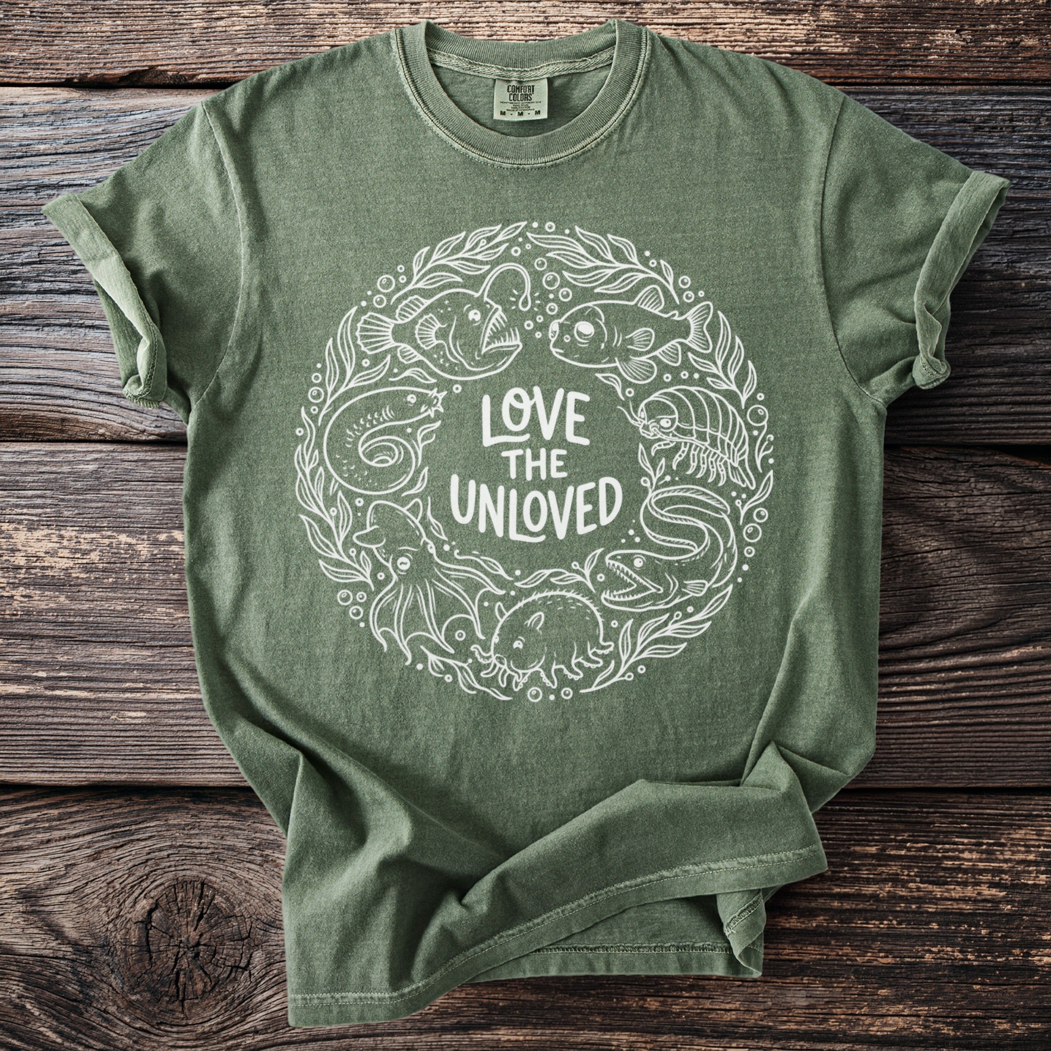 Green t-shirt with white circular print of sea creatures and text "Love the Unloved."