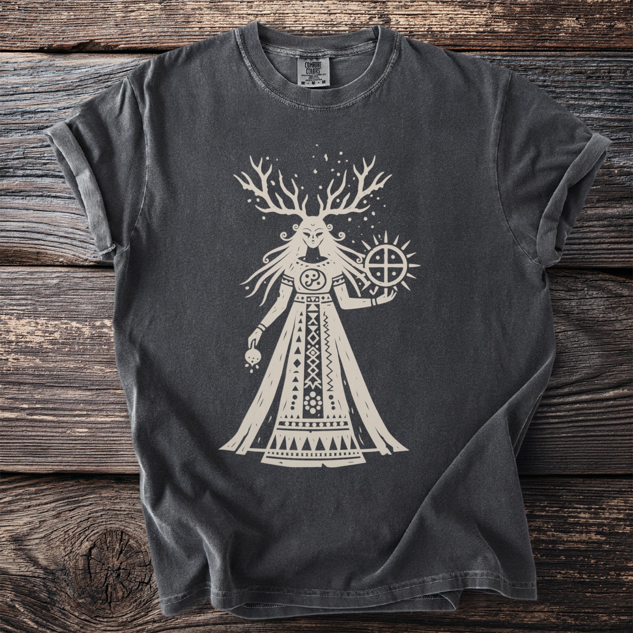 Dark gray t-shirt with a stylized cream graphic of a antlered female deity holding a sun symbol.